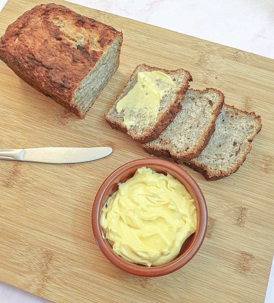 Three slices of pear and banana load next to a dish of butter.