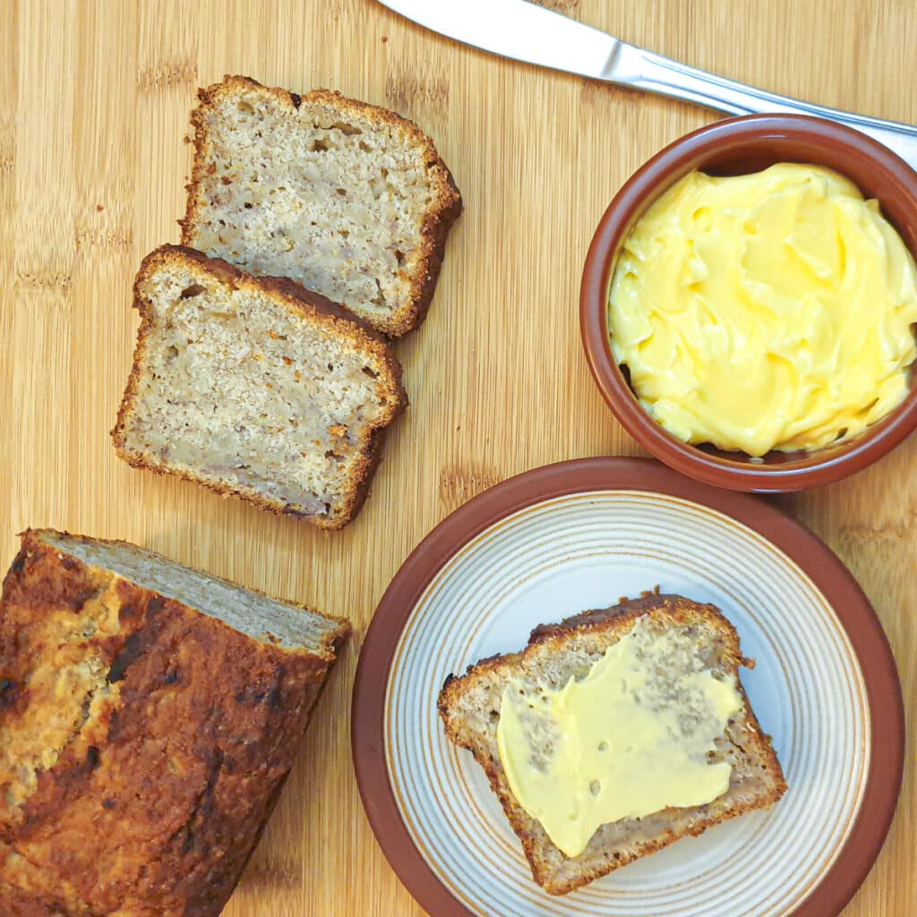 Overhead shot of pear and banana bread on a plate with butter.