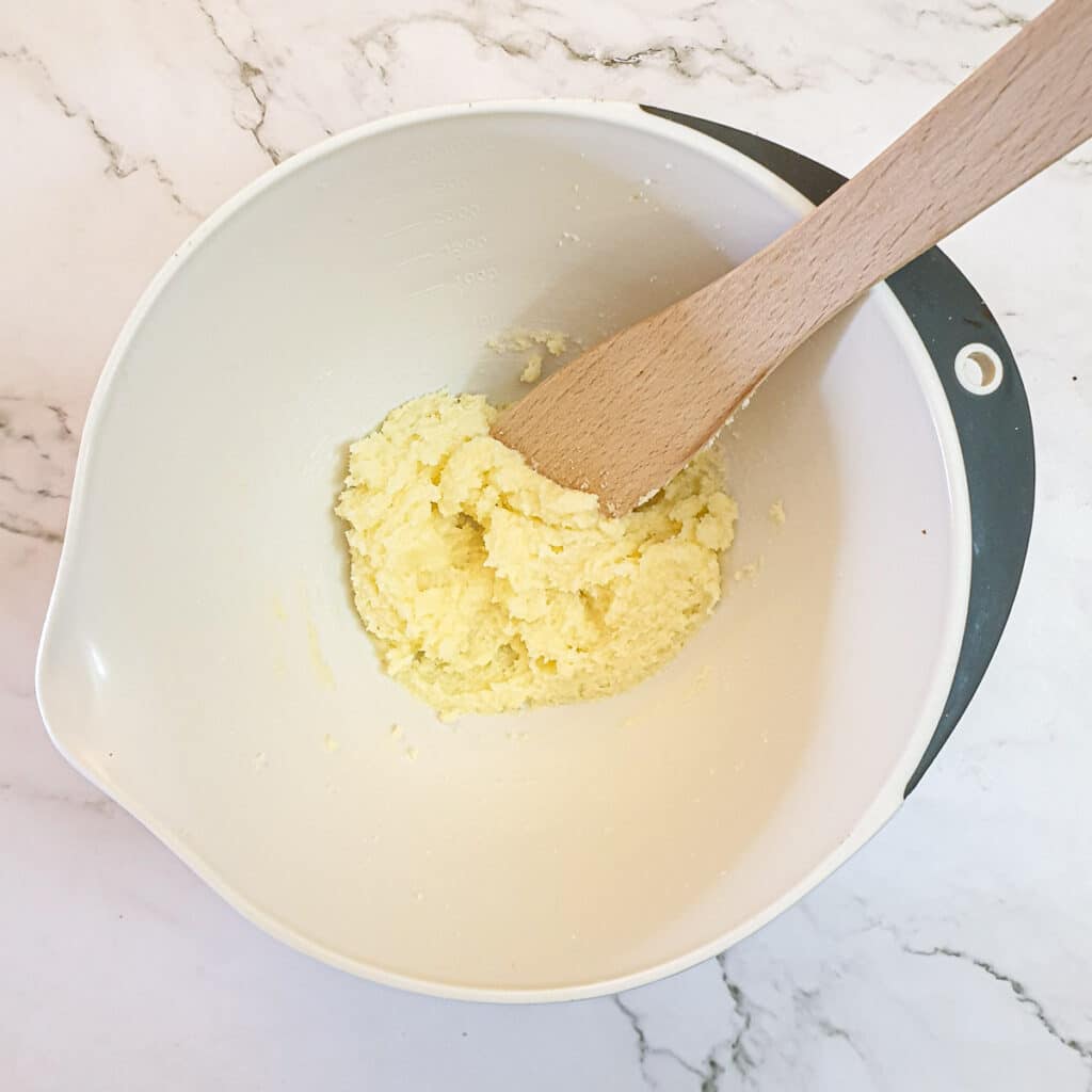 Butter and sugar creamed together in a mixing bowl.