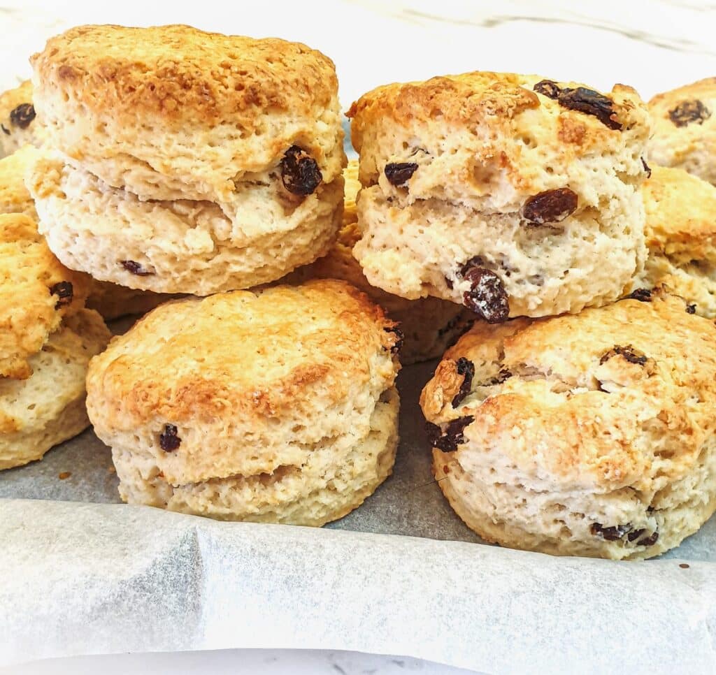 A pile of sultana scones on a baking tray.