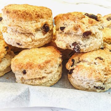 A pile of sultana scones on a baking tray.