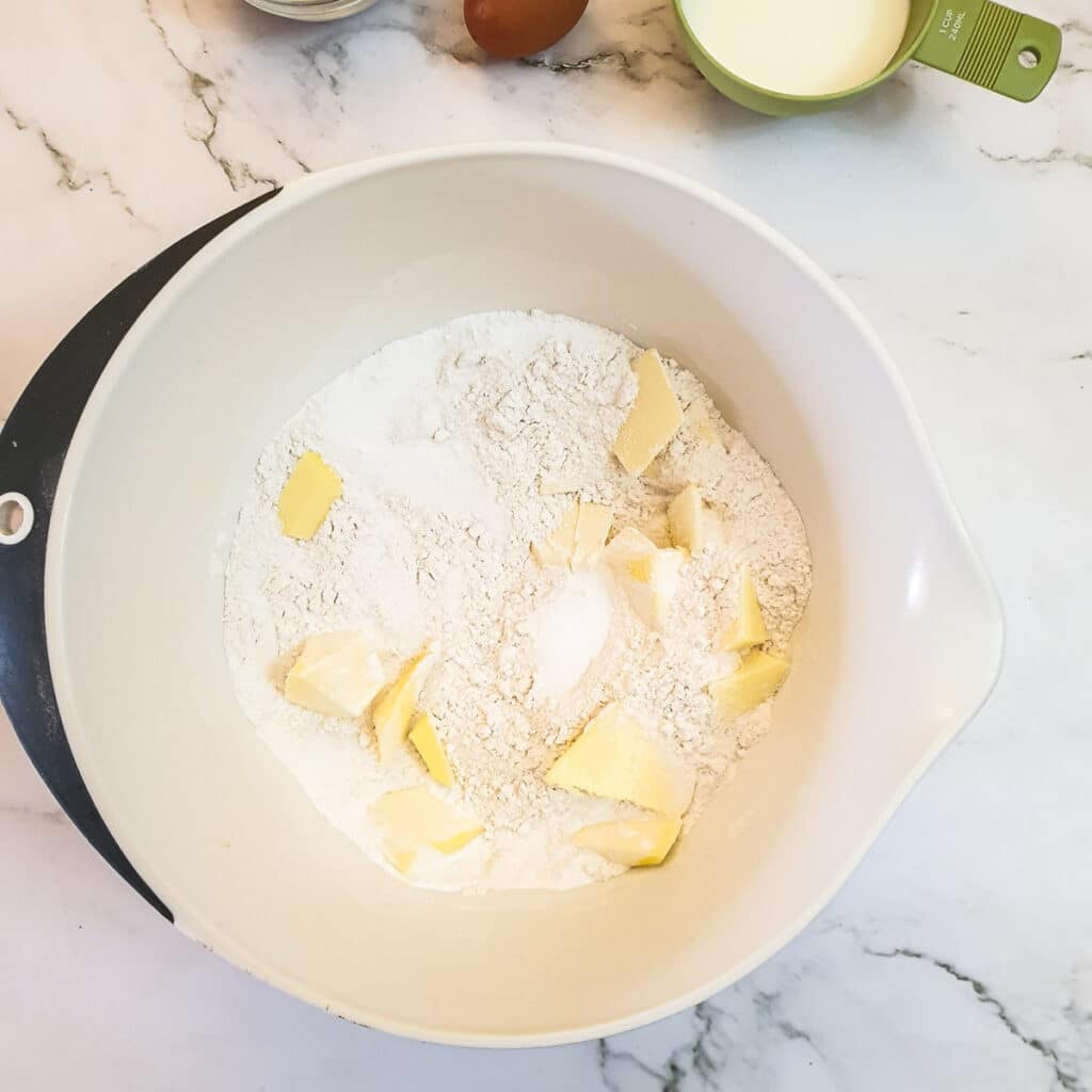 Cubed butter in a mixing bowl with flour.