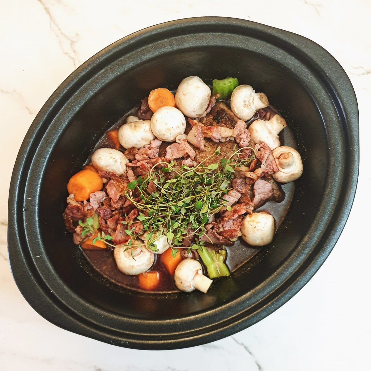 Meat and vegetables ready to be cooked in a slow-cooker.