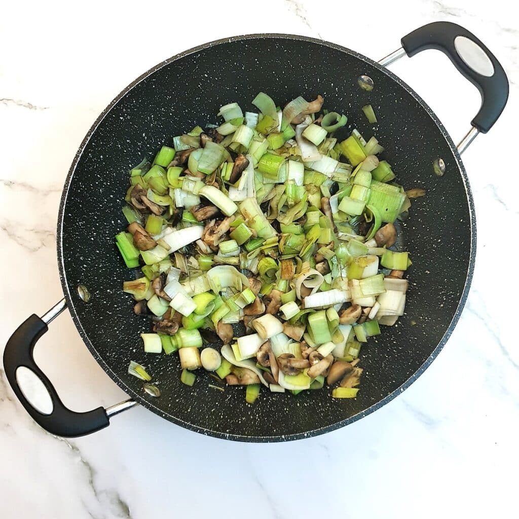 Leeks and onions in a frying pan.