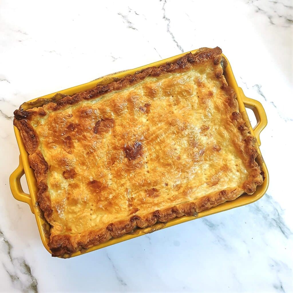 Overhead shot of a baked chicken, leek and mushroom pie.