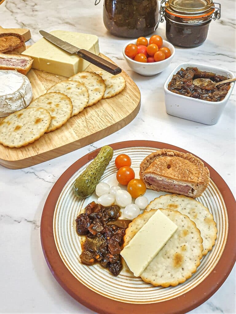 Green tomato chutney on a plate with crackers and cheese.