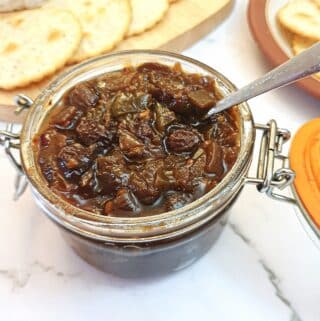 An open jar of green tomato chutney.