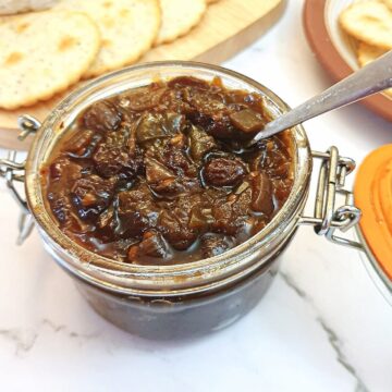 An open jar of green tomato chutney.