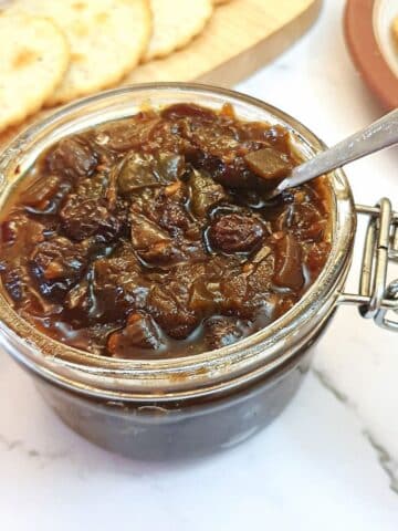 An open jar of green tomato chutney.