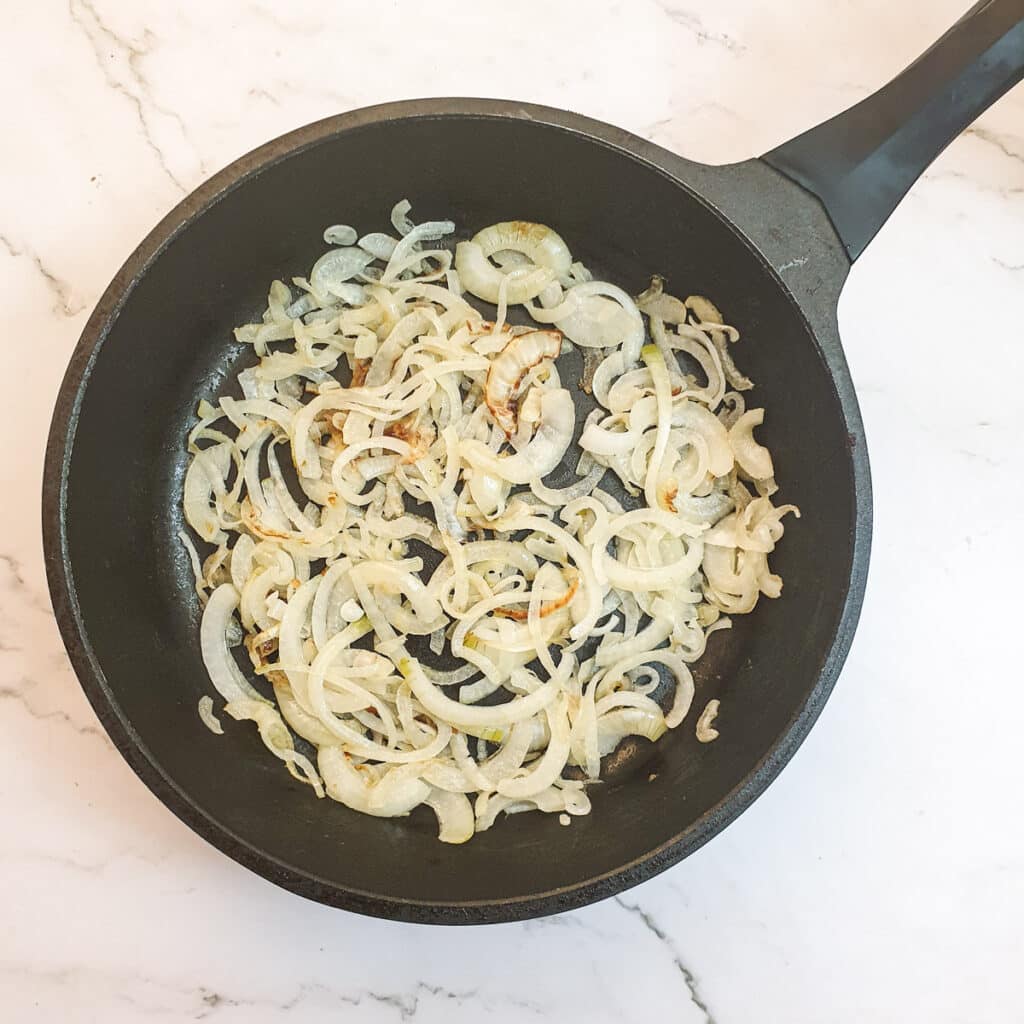 Sliced onions in a frying pan.