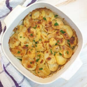 A dish of boulangere potatoes with a crispy cheese topping.