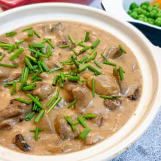 A dish of slow-cooker beef stroganoff garnished with chopped chives.