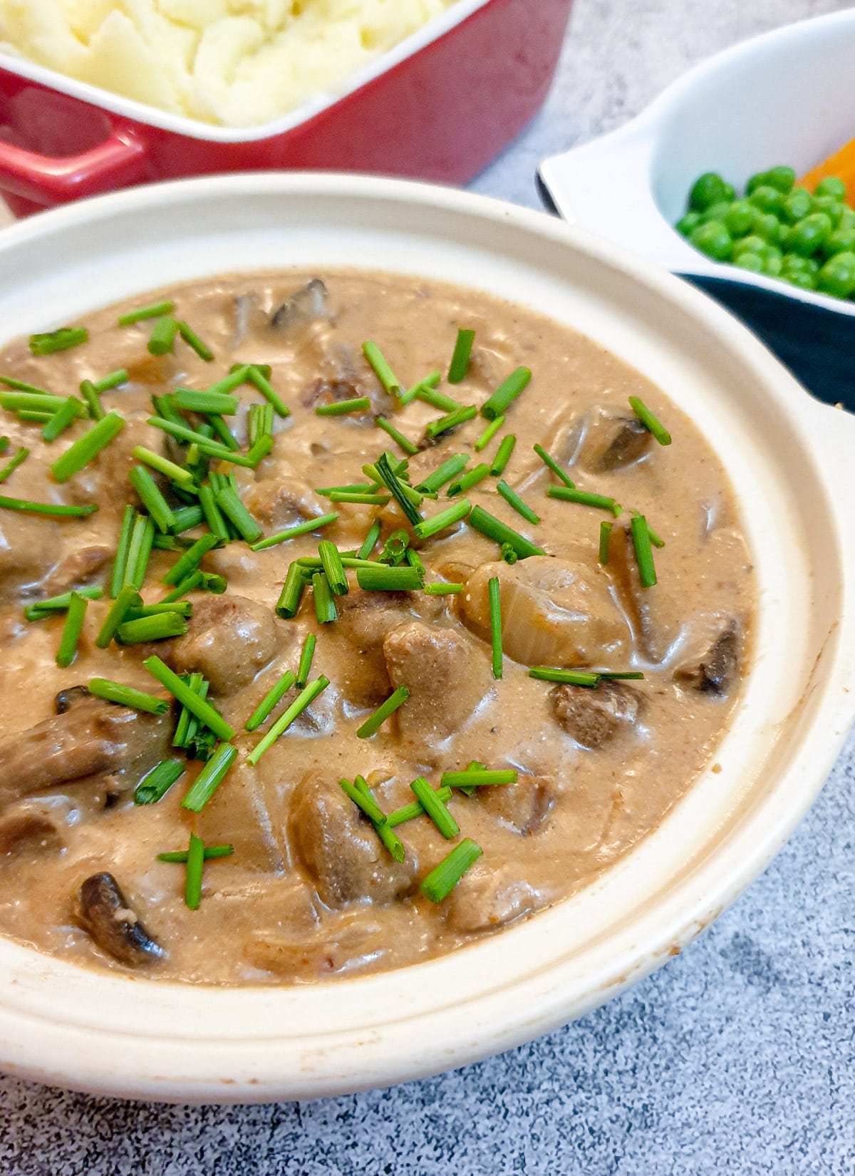 A dish of slow-cooker beef stroganoff garnished with chopped chives.