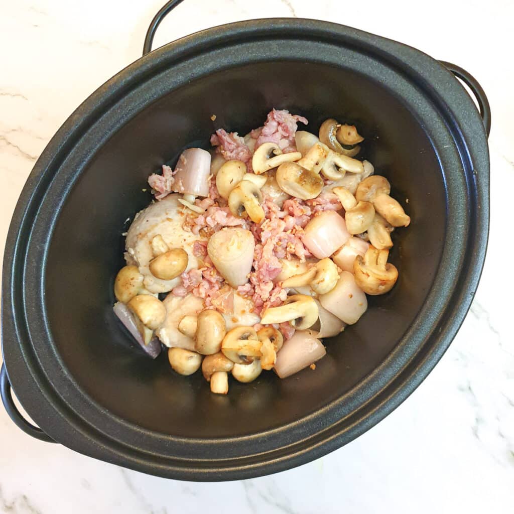 Chicken, bacon, shallots and mushrooms in a slow cooker.