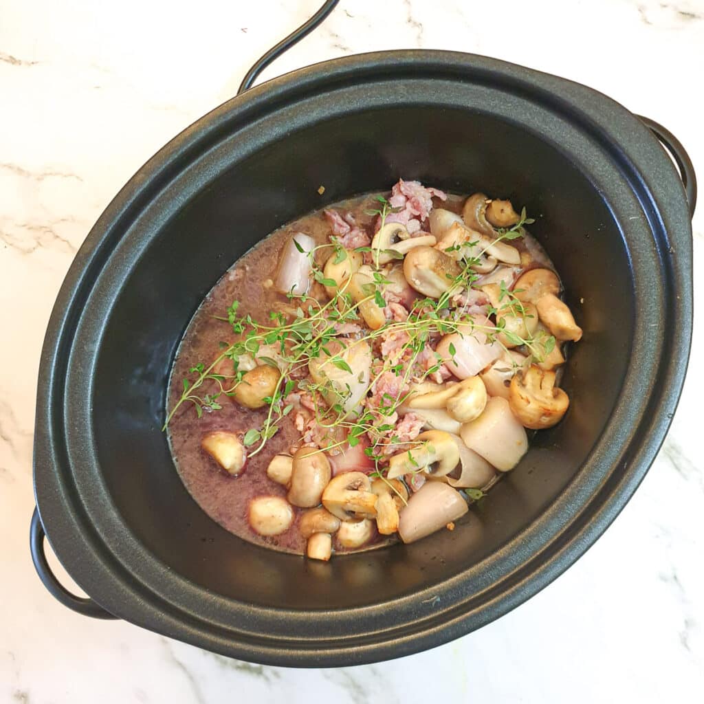 All the ingredients for coq au vin in a slow-cooker.