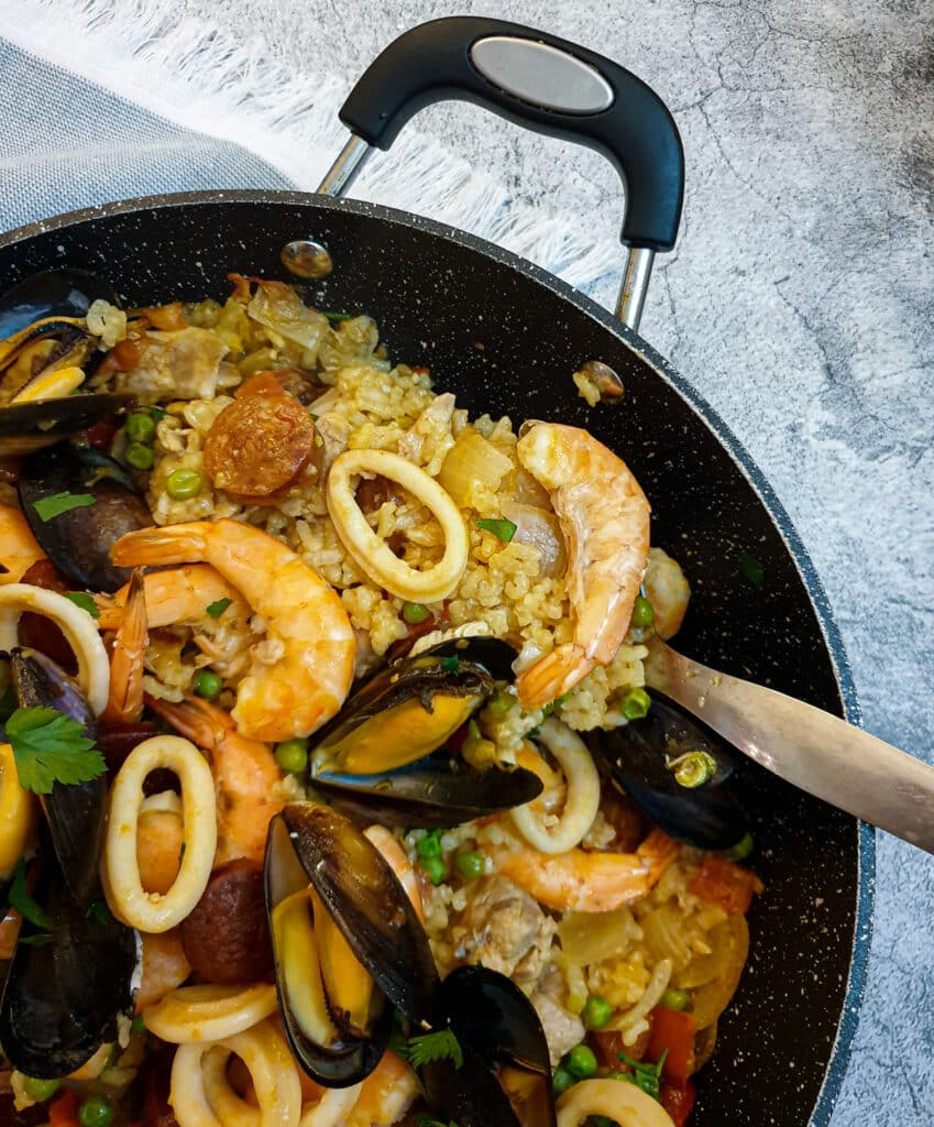 Close up of a dish of paella, showing the rice.