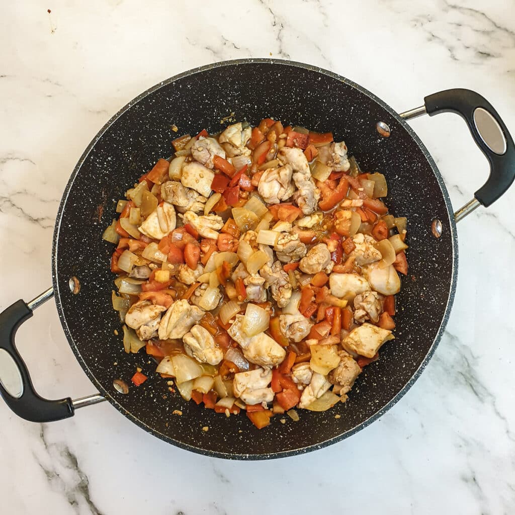 Tomatoes stirred into the chicken, onions and peppers.