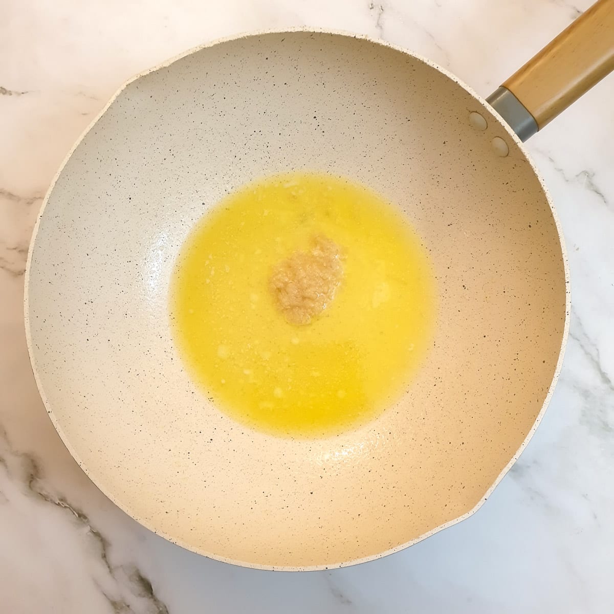 Butter, oil and crushed garlic heating in a wok.