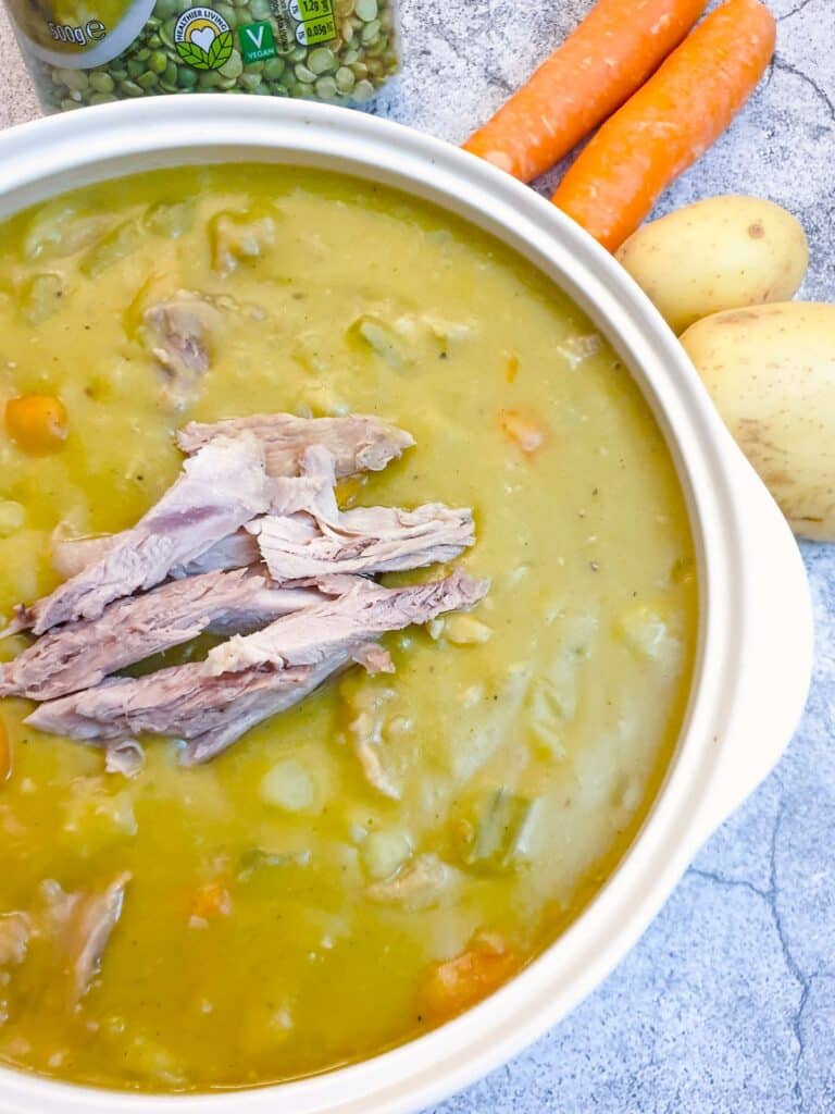 Close up of a serving dish of pea and ham hock soup.