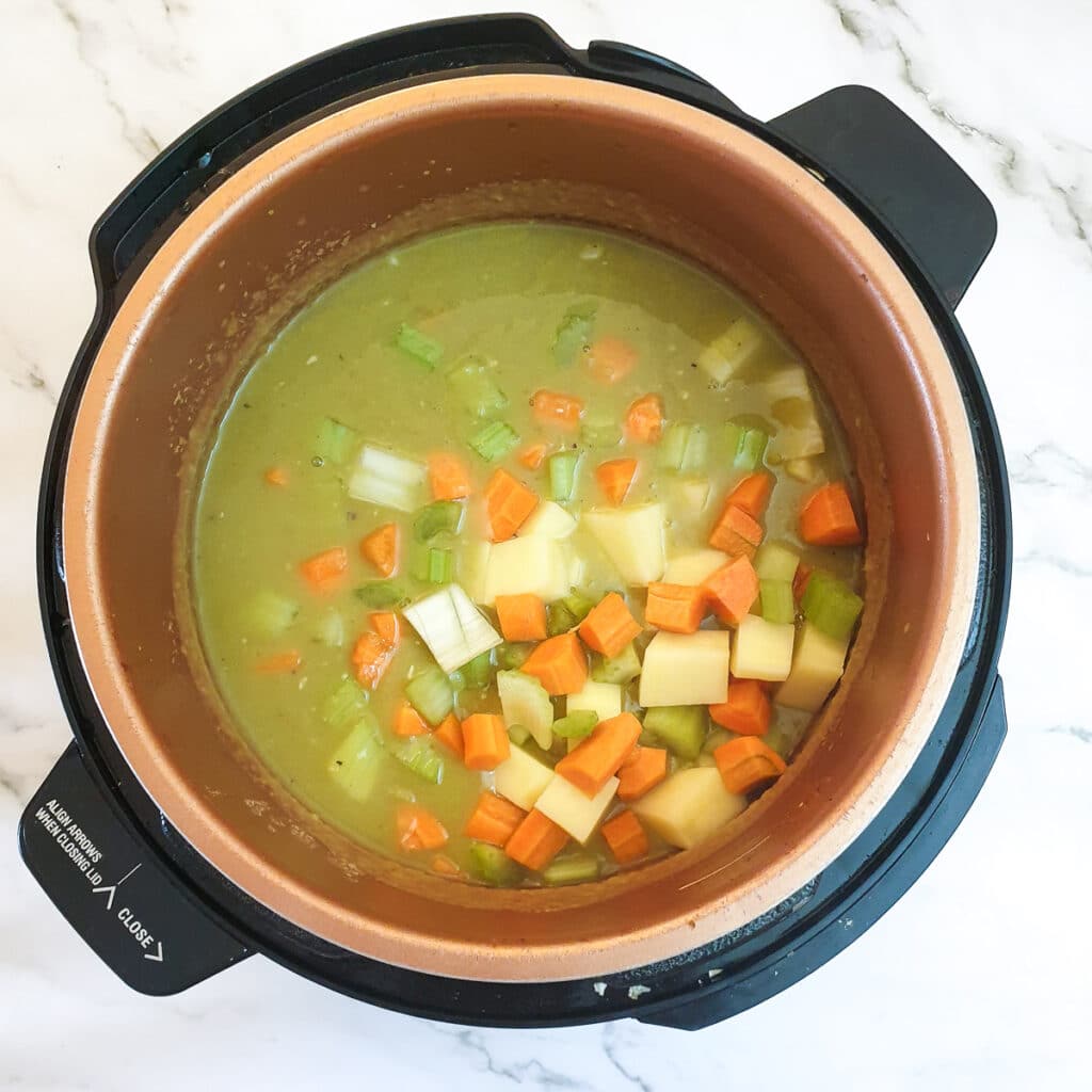 Carrots, celery and potatoes in a pressure cooker with split peas and stock.