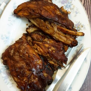 A pile of succulent barbeque pork spare ribs on a plate.