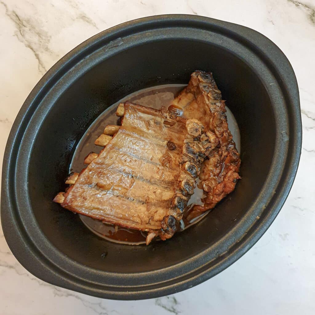 Cooked pork spare ribs in a slow cooker.