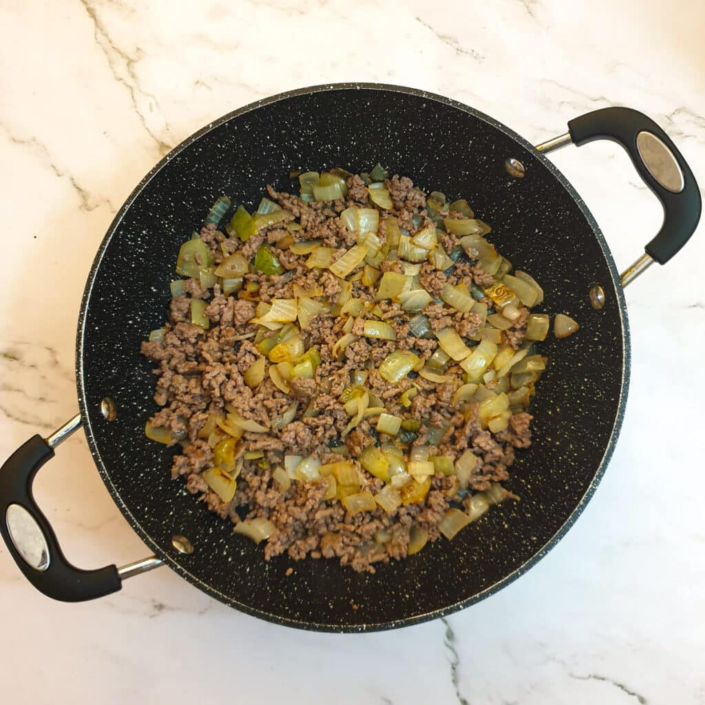 Beef mince and onions being browned in a pan.