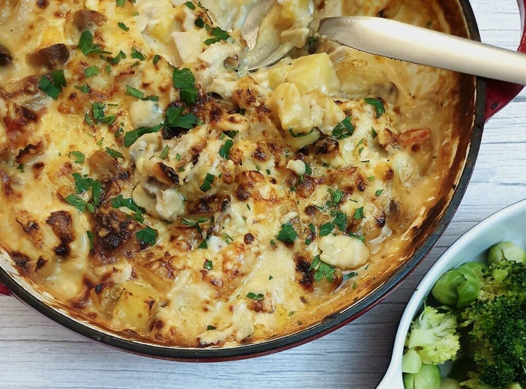 A close up of dish of cheesy potato and chicken bake.