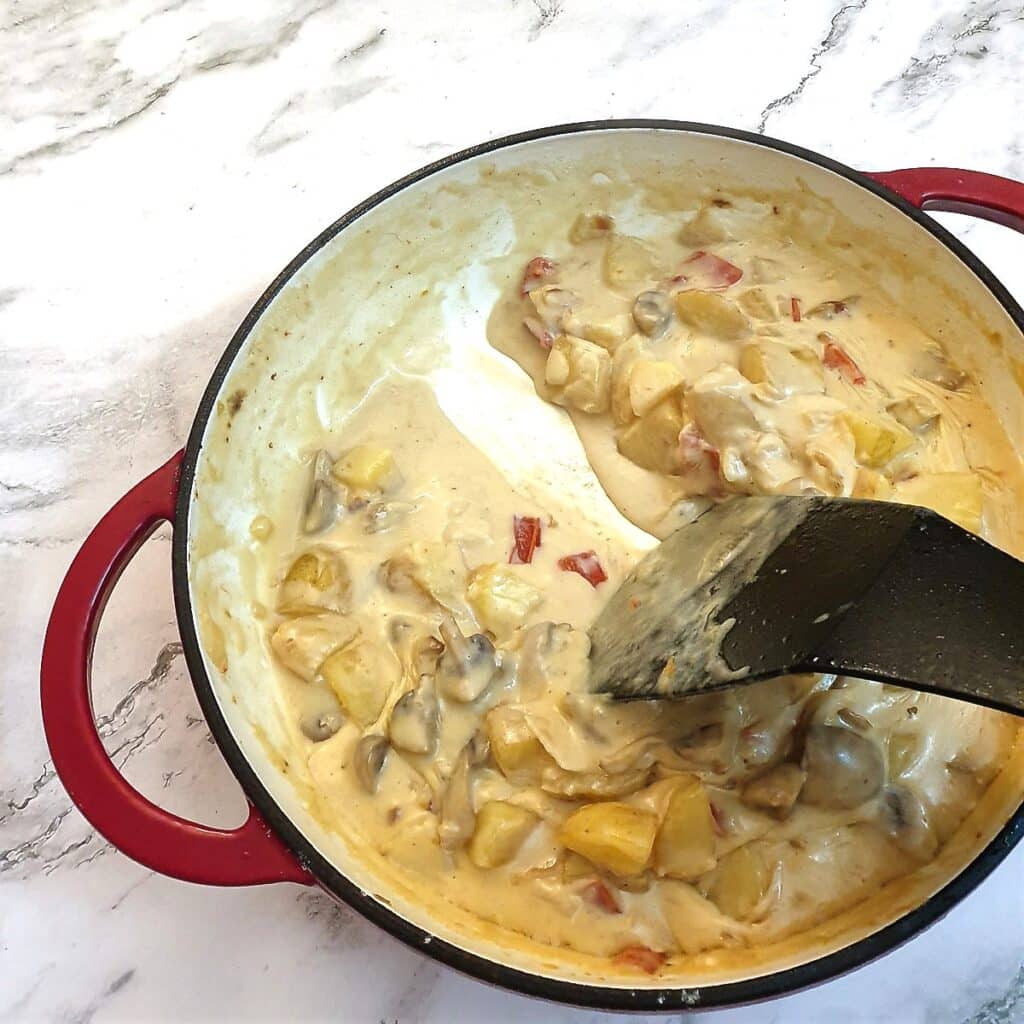 A spoon being drawn through the cheese sauce showing the consistency.