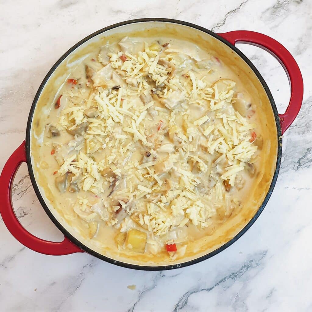 Grated cheese sprinkled over the chicken and potato bake.