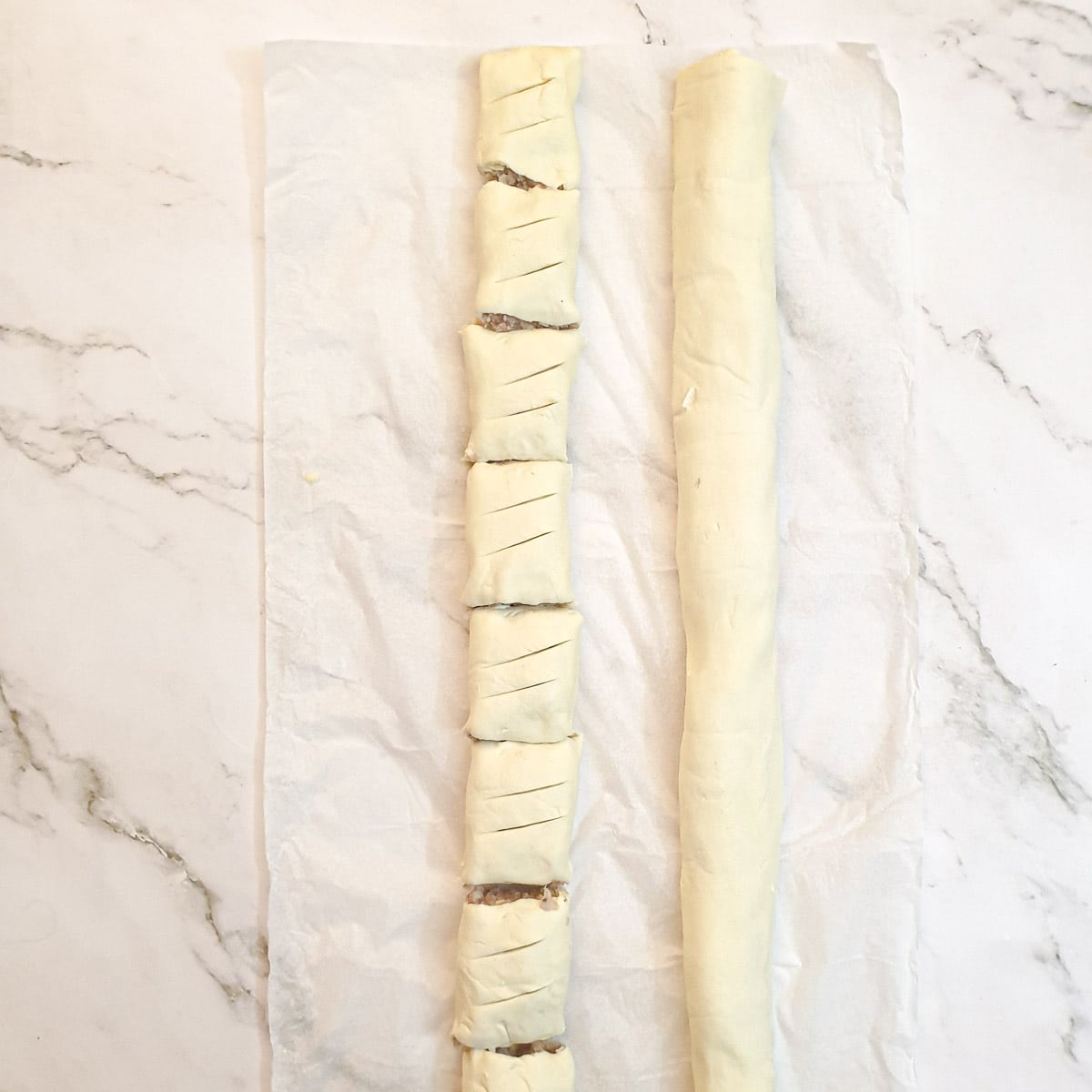 Sausage rolls being cut to shape.