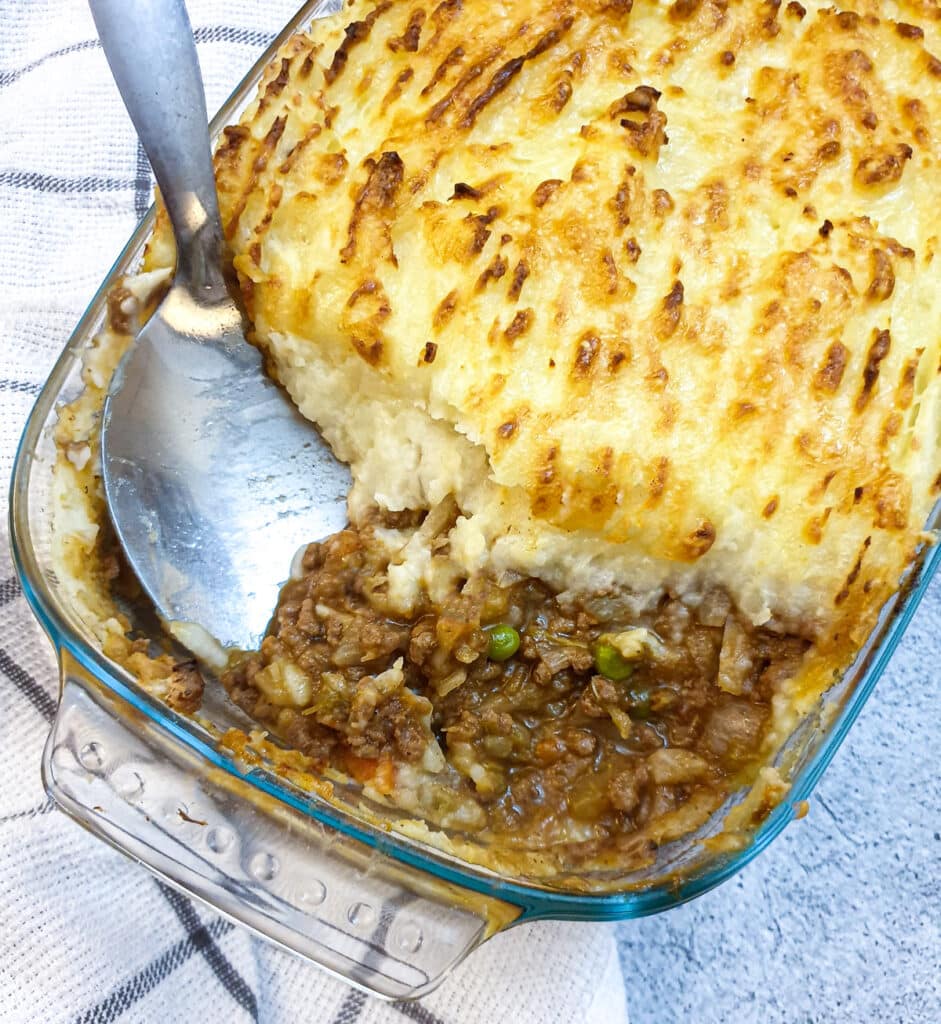 Cottage pie, showing the juicy meat and vegetables underneath the potatoes.