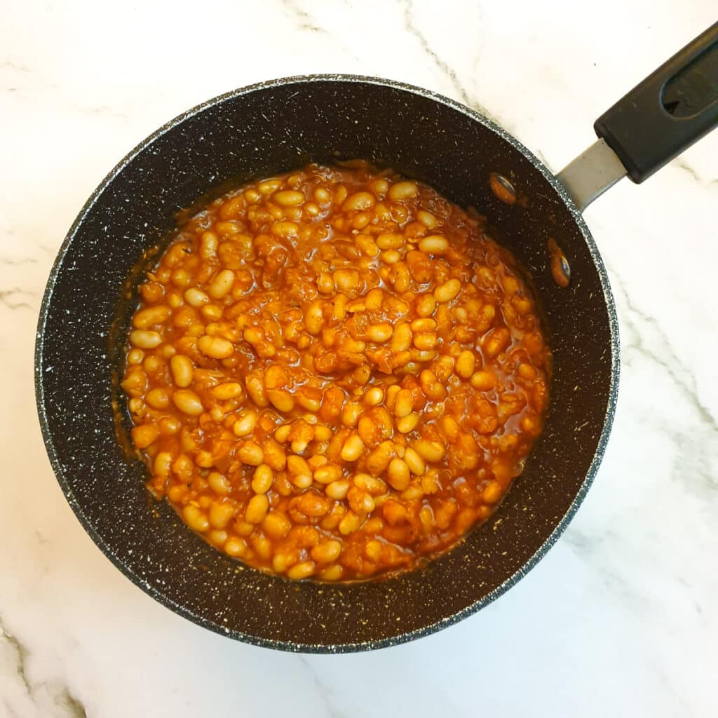 A saucepan of cooked baked beans.