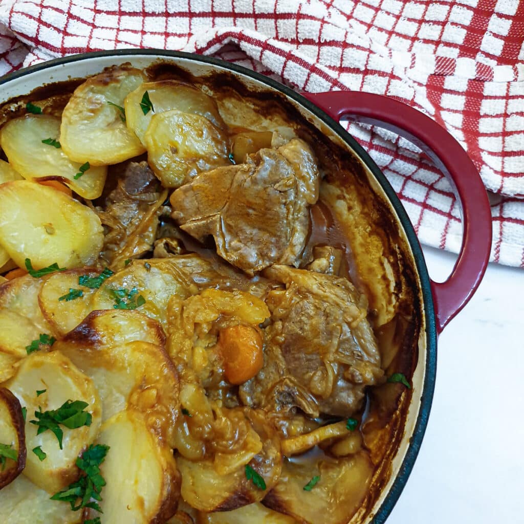 Close up of a lancashire hotpot showing the lamb under the potatoes.