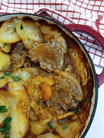 Close up of a lancashire hotpot showing the lamb under the potatoes.