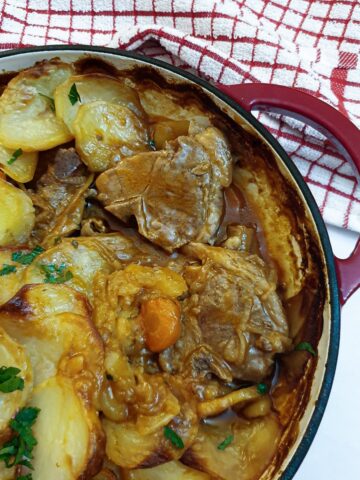 Close up of a lancashire hotpot showing the lamb under the potatoes.