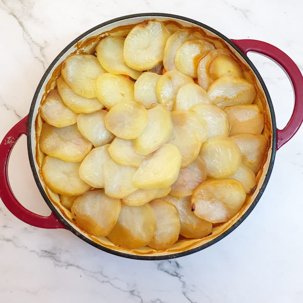 A dish of lancashire hotpot before the potatoes have been browned.