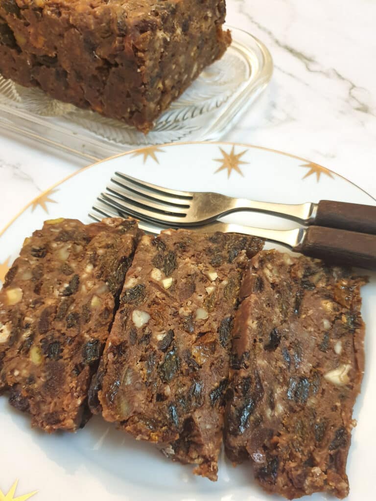 A closeup of three slices of Christmas cake on a plate.