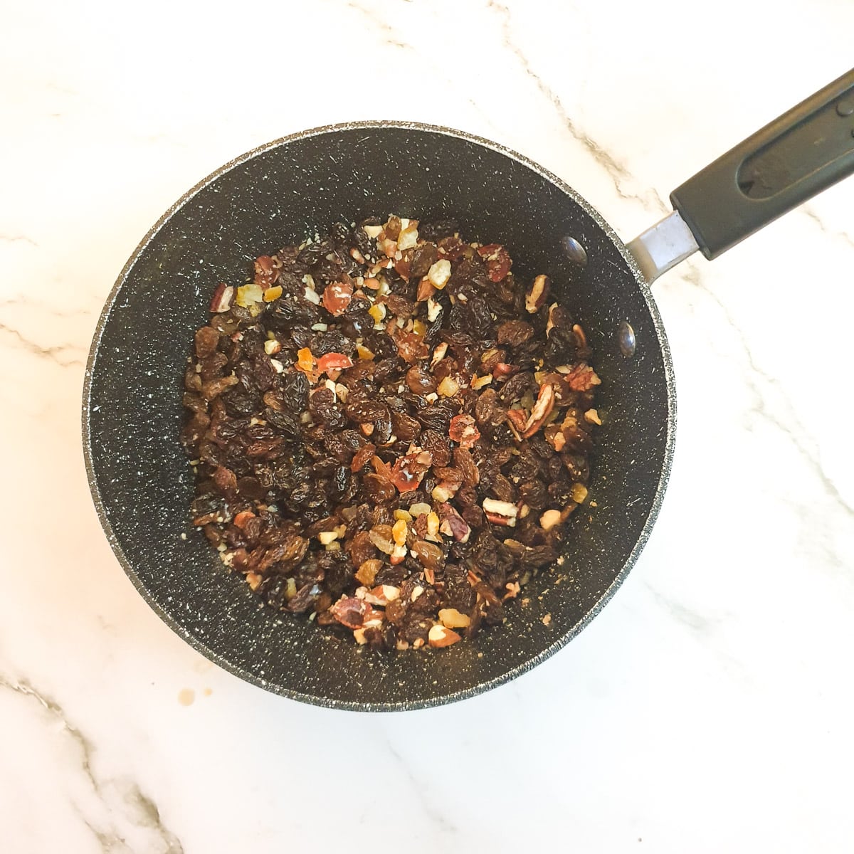 Mixed dried fruit in a saucepan.