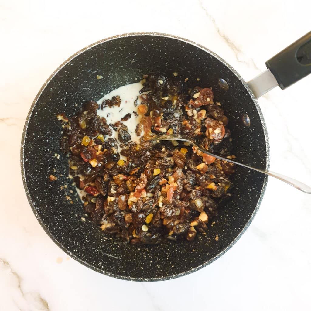 Dried fruit in a saucepan with the addition of milk and sherry.