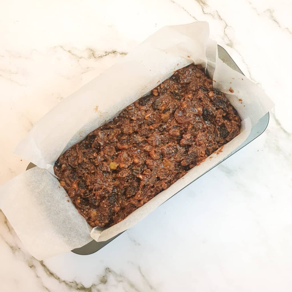 The fruit cake mixture in a loaf pan.