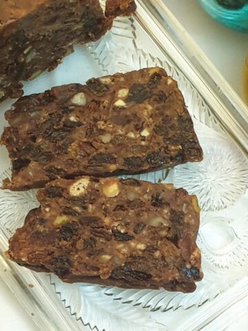 Two slices of no-bake Christmas cake on a glass tray, showing the texture of the cake.