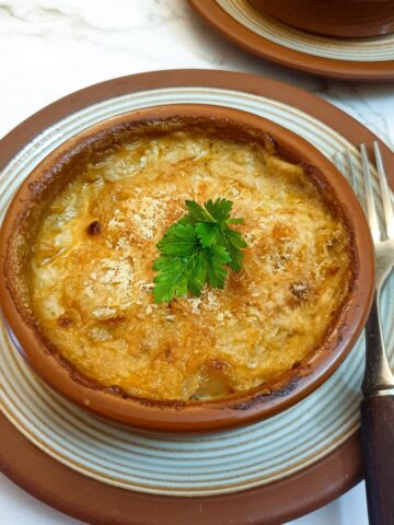 Close up of a dish of prawn and scallop au gratin.