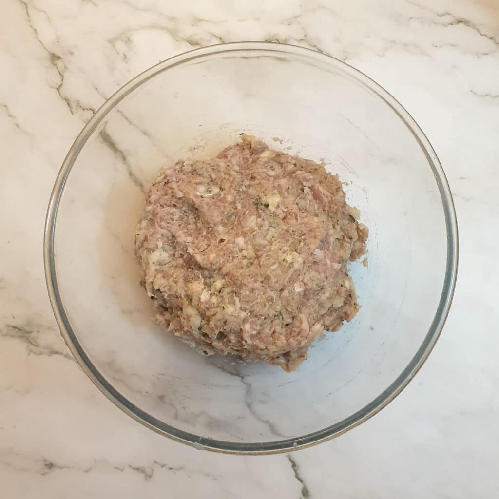 Sage and onion stuffing mixed in a glass bowl.