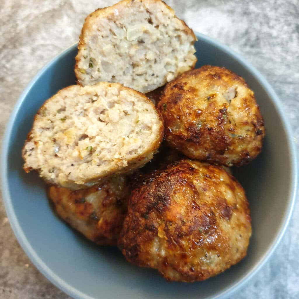 sage and onion pork stuffing balls in  dish.