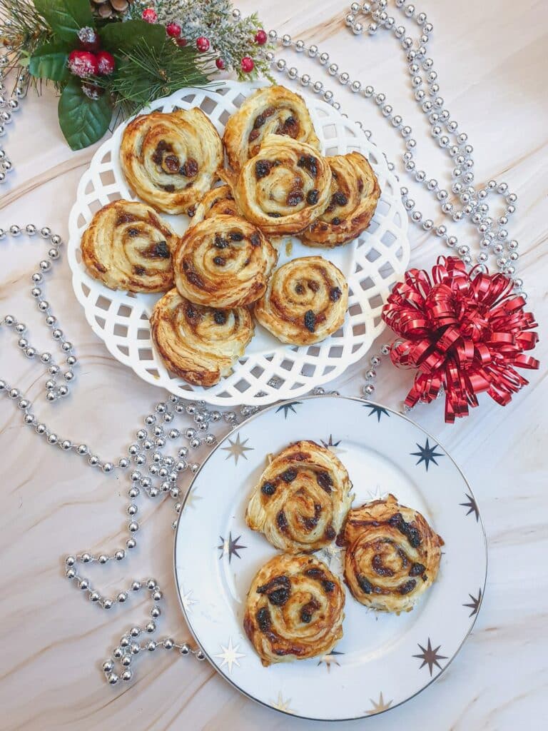 Overhead shot of two plates of Christmas mince pinwheels.