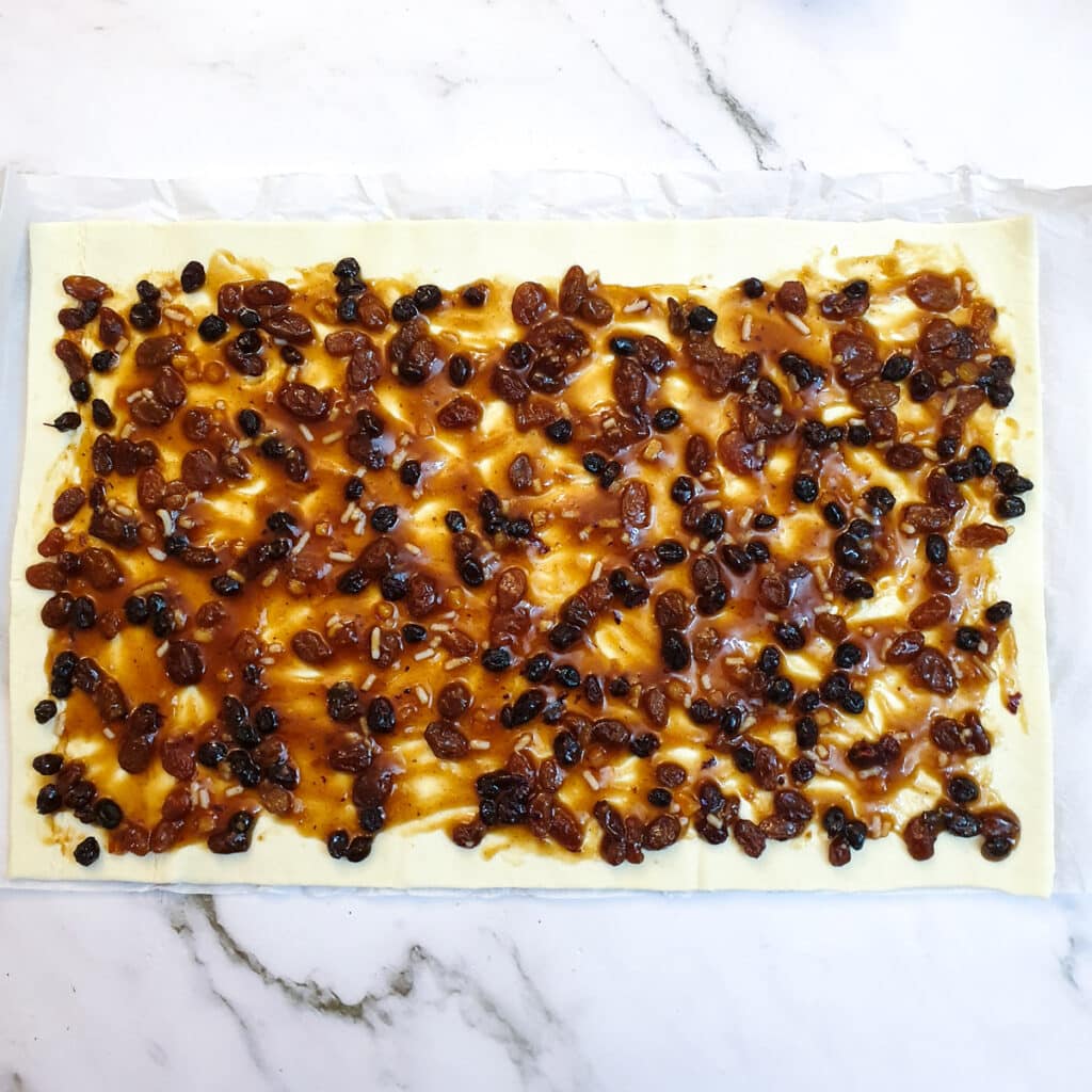 A sheet of puff pastry spread with fruit mincemeat.