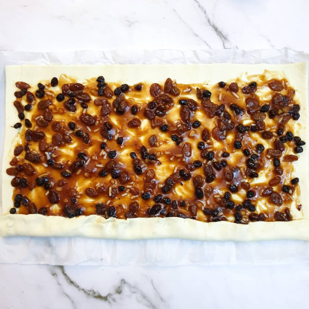 Puff pastry and fruit mincemeat being rolled into a sausage shape.