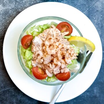 Overhead shot of a dish of poor man's crayfish on a white plate.