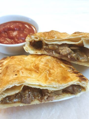 A steak and onion bake cut in half to show the filling.